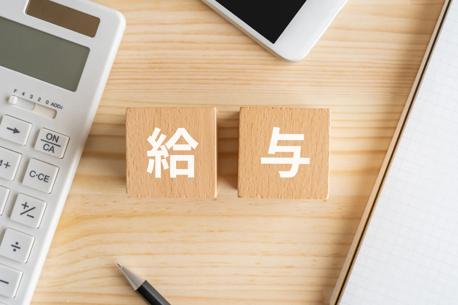 給与と書かれた積み木と電卓